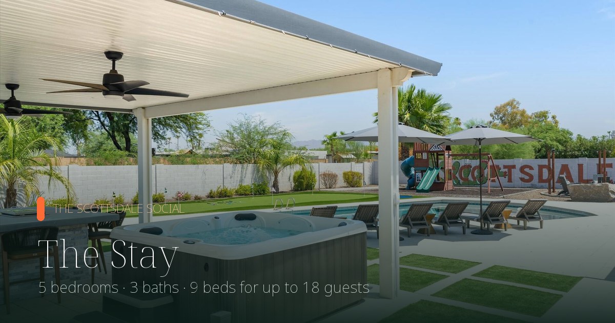 Covered patio with hot tub, lounge seating and turf lawn at The Scottsdale Social